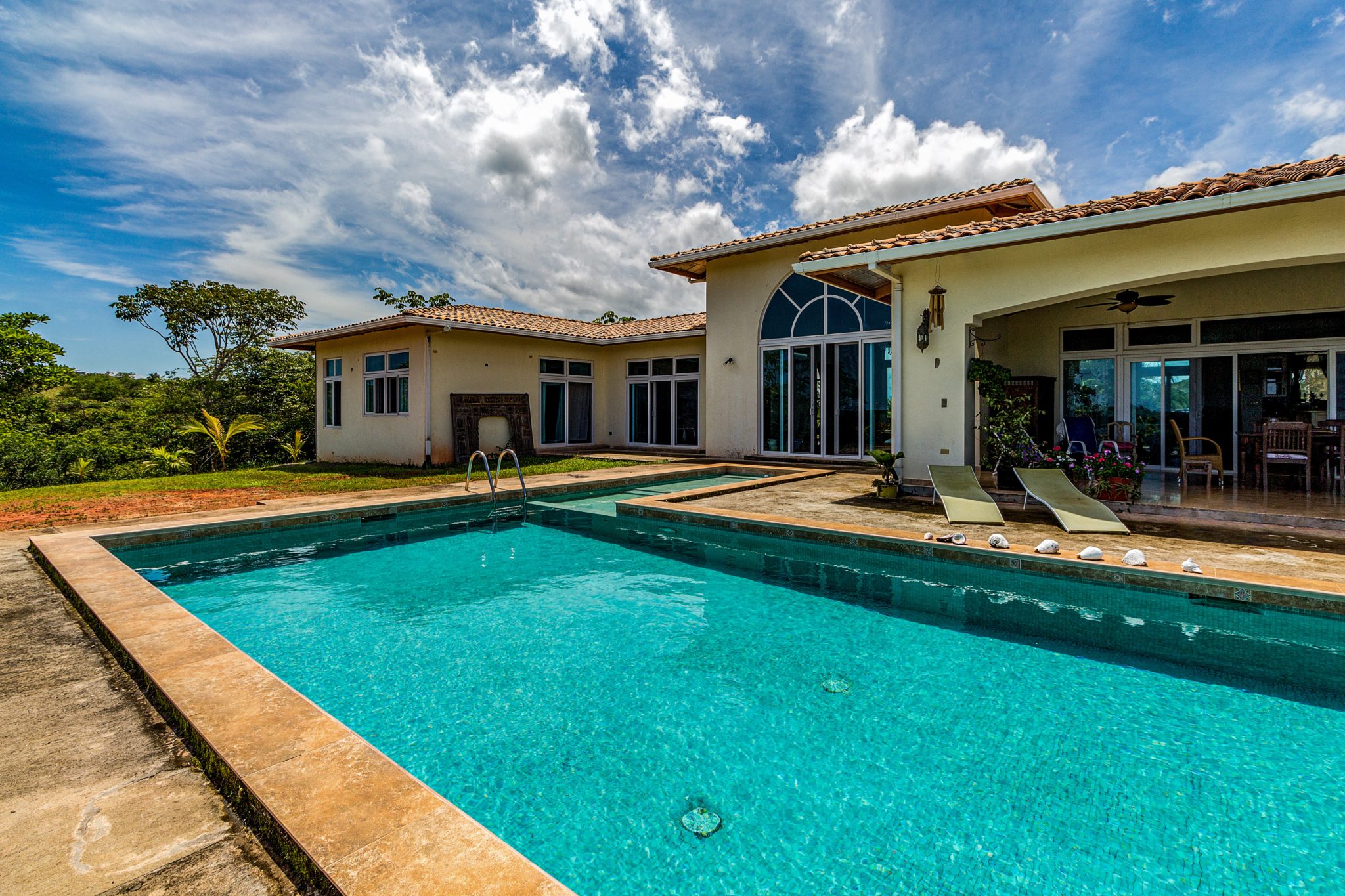 Backyard of home with pool and outdoor furniture for Home Insurance.