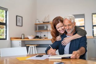 Loving woman embracing senior man man signs up for employee benefits